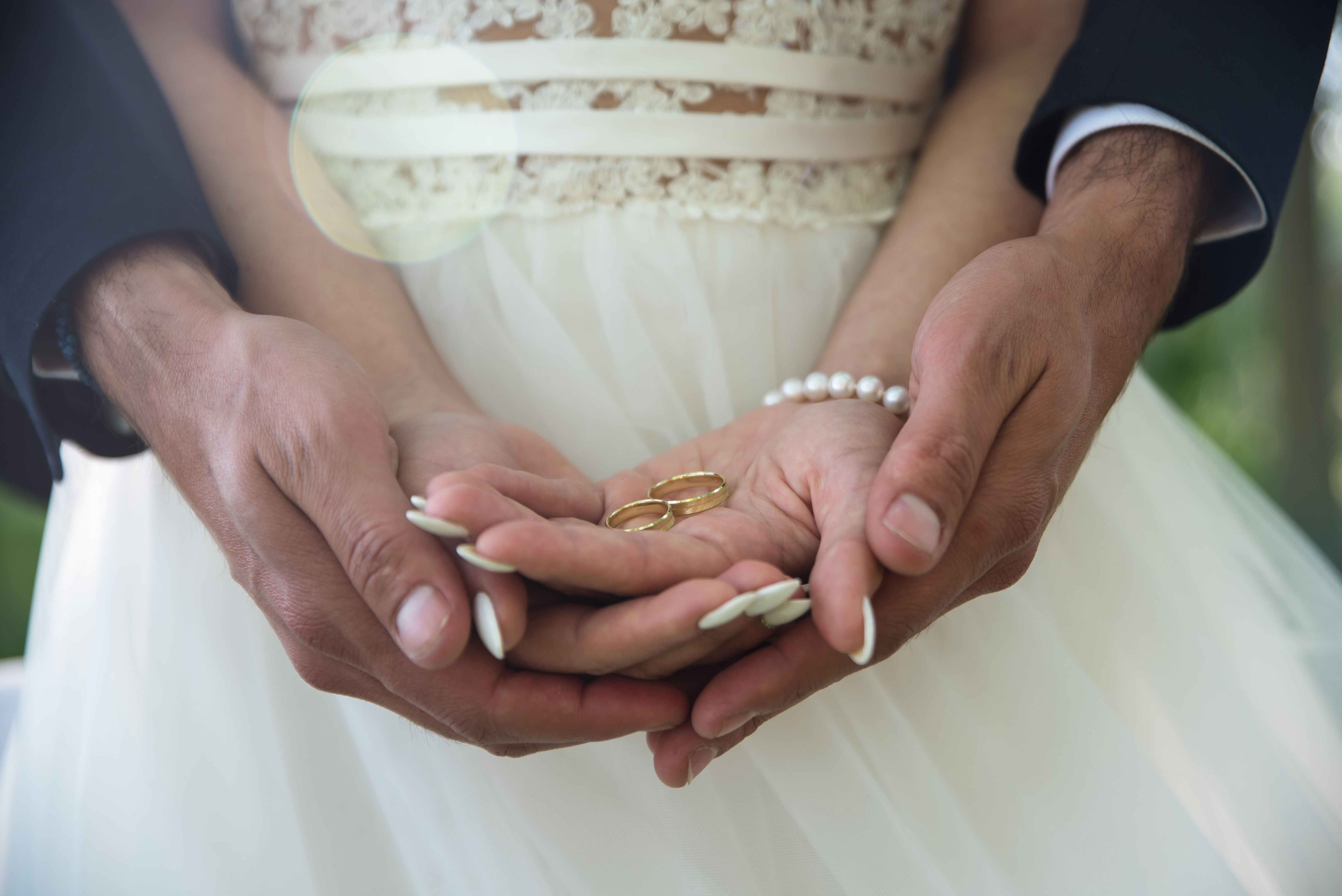 A man and woman holding hands with wedding rings.